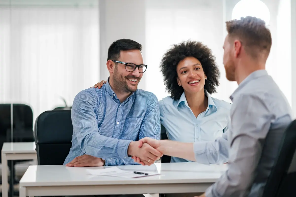 happy-couple-shaking-hands-bank-loan-officer-1200x800