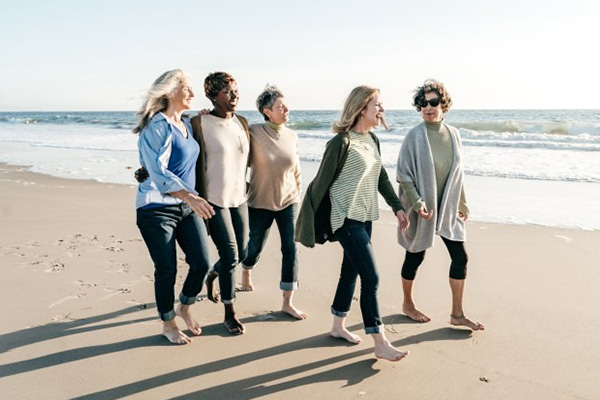 An image of a group of middle aged women walking together on the beach